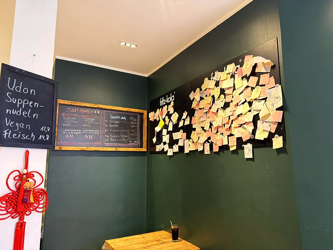 Grüne Wand mit Gäste-Notizen und Speisetafeln